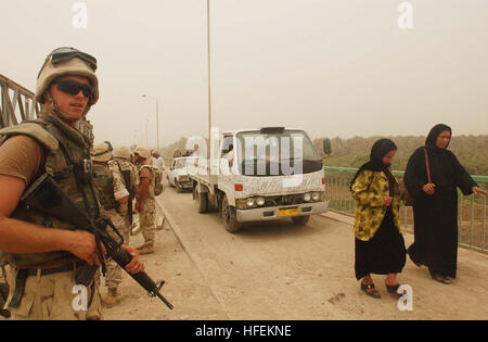 030526-N-5362A-015 Hillah, Iraq (26 maggio 2003) -- Un U.S. Navy Seabee, assegnato Naval Mobile Battaglione di costruzione una trentina di tre (NMCB-133), sorge security watch come cittadini locali passano da durante un progetto per ricostruire la Sarabadi ponte sul fiume Tigri vicino al Hillah. NMCB-133 è al lavoro per costruire ponti danneggiati durante la guerra a sostegno dell'Operazione Iraqi Freedom. Operazione Iraqi Freedom è la multi-nazionali della Coalizione sforzo per liberare il popolo iracheno, eliminare in Iraq le armi di distruzione di massa e la fine del regime di Saddam Hussein. Stati Uniti Navy foto dal fotografo compagno del primo Clas Foto Stock