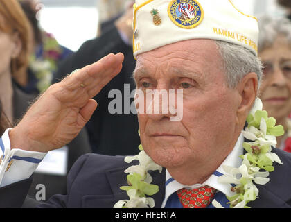 Durante la commemorazione del 62° anniversario dell'attacco di Pearl Harbor, il Comandante di Stato delle Hawaii dei Veterani americani disabili saluta il distintivo nazionale allo USS Arizona Memorial. La cerimonia include il cacciatorpediniere USS o'Kane (DDG 77) che rende onore, presentazioni di ghirlande, un saluto di 21 cannoni e rubinetti giocati. Foto Stock