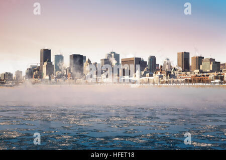 Il vapore ascendente dal congelati St Lawrence river a sunrise, con il quartiere centrale della Vecchia Montreal in background. Foto Stock