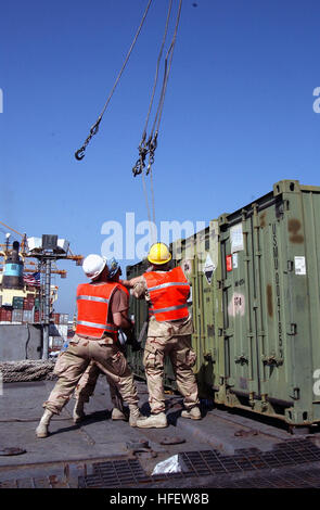 040227-N-0743B-021 Mina Ash-Shu'aibah, Kuwait (feb. 27, 2004) - membri assegnati al Naval Expeditionary Supporto Logistico forza in avanti alfa, spostare i cavi in posizione in modo da fissare a contenitori di carico essendo off-caricato dal militare Sealift Command (MSC) fast sealift nave USNS Bellatrix (T-AKR 288). MSC Sealift militari di comando è il fornitore di servizi di trasporto per il Dipartimento della difesa con la responsabilità di fornire sealift strategico e l'oceano per il trasporto di tutte le forze militari all'estero. Stati Uniti Foto di Marina dal giornalista di terza classe Eric L. Beauregard. (Rilasciato) Navy US 040227-N-0743B-021 Foto Stock