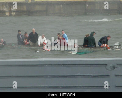 040306-N-0000X-001 Baltimore, Md. (6 marzo 2004) Ð i passeggeri dell'acqua-taxi si aggrappano alla carena del rovesciamento pontoon boat in BaltimoreÕs porto interno come un U.S. Navy barca si avvicina per assistere nelle operazioni di soccorso. Riservisti dalla Riserva Marina Centro (NRC) Baltimore assistito nel salvataggio di più di una dozzina di passeggeri nel tardo pomeriggio, 6 marzo. Il comando Master Chief Melvin Johnson e i sistemi di informazione tecnico di terza classe Edward Mendez visto l'acqua taxi capovolgimento come essa ha tentato di manovra in heavy mari e venti. Essi hanno immediatamente chiamato 911, e della Cmdr. Petersen Decker, comm Foto Stock