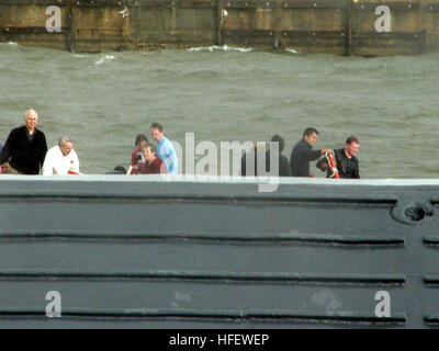 040306-N-0000X-007 Baltimore, Md. (6 marzo 2004) Ð i passeggeri dell'acqua-taxi si aggrappano alla carena del rovesciamento pontoon boat in BaltimoreÕs porto interno come un U.S. Navy barca si avvicina per assistere nelle operazioni di soccorso. Riservisti dalla Riserva Marina Centro (NRC) Baltimore assistito nel salvataggio di più di una dozzina di passeggeri nel tardo pomeriggio, 6 marzo. Il comando Master Chief Melvin Johnson e i sistemi di informazione tecnico di terza classe Edward Mendez visto l'acqua taxi capovolgimento come essa ha tentato di manovra in heavy mari e venti. Essi hanno immediatamente chiamato 911, e della Cmdr. Petersen Decker, comm Foto Stock