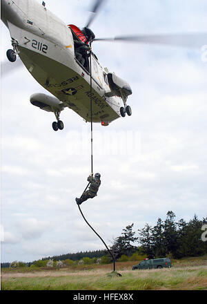 040408-N-8921O-004 Oak Harbor, nello Stato di Washington (Apr. 08, 2004) - equipaggio Survival Equipmentman 2a classe John Mann, di San Diego, California, corde veloce al di fuori di un UH-3H Sea King elicottero. Petty Officer Mann è assegnato per l'eliminazione degli ordigni esplosivi Unità Mobile undici (EODMU-11). L'unità è in conduzione veloce e corda rappelling esercizi per aiutare a preparare la squadra per la lotta contro le situazioni. Stati Uniti Navy foto dal fotografo di Mate Airman Chris Otsen. (Rilasciato) Navy US 040408-N-8921O-004 equipaggi Equipmentman sopravvivenza 2a classe John Mann, di San Diego, California, corde veloce al di fuori di un UH-3H Sea King elicottero Foto Stock