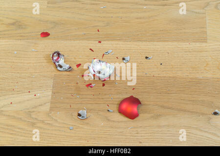Frammenti di rotto una palla di natale su un pavimento di legno Foto Stock