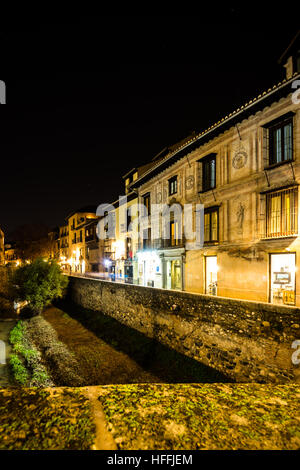 Scena urbana di un fiume che attraversa la parte vecchia della città di Granada, Spagna, scattata di notte Foto Stock