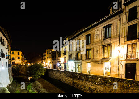 Scena urbana di un fiume che attraversa la parte vecchia della città di Granada, Spagna, scattata di notte Foto Stock