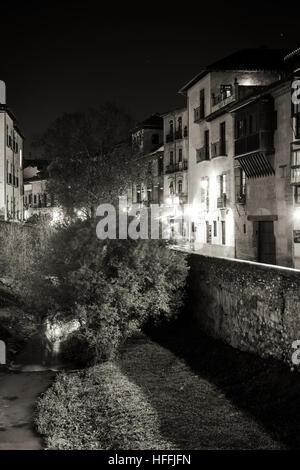 Scena urbana di un fiume che attraversa la parte vecchia della città di Granada, Spagna, scattata di notte Foto Stock