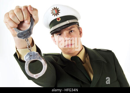 Giovane funzionario di polizia holding manette Foto Stock