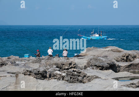 [Solo uso editoriale] i pescatori e la pesca in barca sulla rocciosa costa orientale dell isola di Taiwan a Hualien county Foto Stock