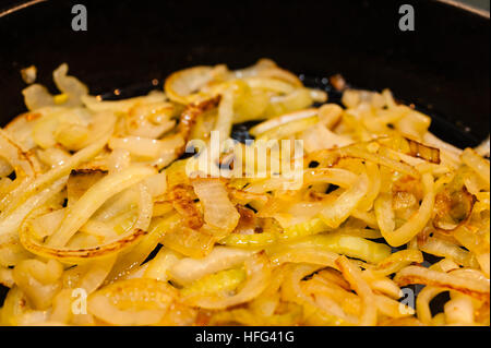 Golden brown, saltato le cipolle in una padella in ghisa. Foto Stock