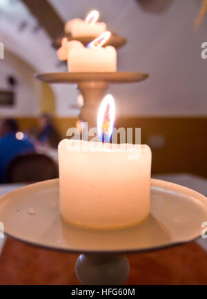 Candele accese su una tavola di legno creano un'atmosfera accogliente, di affetto e di amore Foto Stock