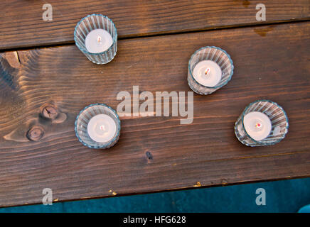 Candele accese su una tavola di legno creano un'atmosfera accogliente, di affetto e di amore Foto Stock