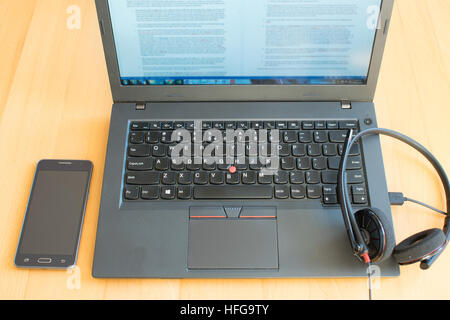 La vista sul laptop , smart phone e cuffie sulla scrivania Foto Stock