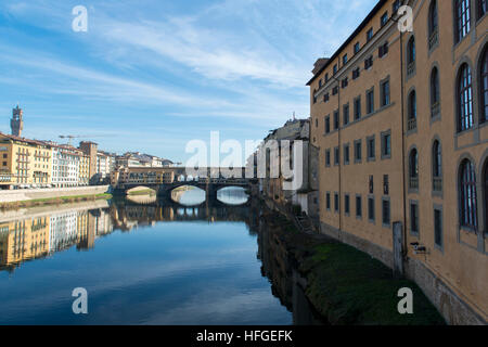 Vista del fiume Arno embankment con architettura e Ponte Vecchio si riflette sull'acqua Foto Stock