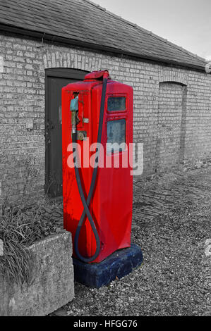 Un vecchio,in disuso, benzina o benzina, la pompa nel Regno Unito in campagna a colori con sfondo monocromo Foto Stock