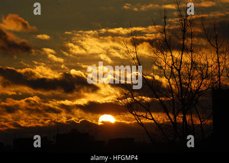 Nuvole scure e giallo arancione tramonto Foto Stock