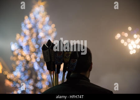 Stuttgart, Germania. 01 gen 2017. Un uomo porta petardi sulla sua spalla nella parte anteriore dell'albero di Natale in piazza Schlossplatz a Stoccarda, Germania, 01 gennaio 2017. Centinaia di persone si sono radunate sulla Schlossplatz square a Stoccarda per festeggiare insieme. Foto: Lino Mirgeler/dpa/Alamy Live News Foto Stock