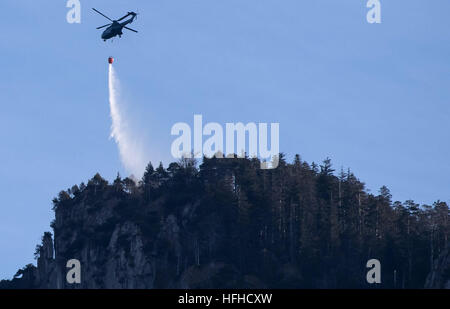 Kochel am See, Germania. 02Jan, 2017. Un elicottero mettendo a fuoco sulla montagna Jochberg in Kochel am See, Germania, 02 gennaio 2017. Un alpinista ha causato un incendio sulla montagna Jochberg. Circa un centinaio di ettari di foresta e campi erano sul fuoco e i vigili del fuoco potrebbe richiedere ancora un paio di giorni in più per estinguere il fuoco, secondo l'amministrazione distrettuale. Foto: Sven Hoppe/dpa/Alamy Live News Foto Stock