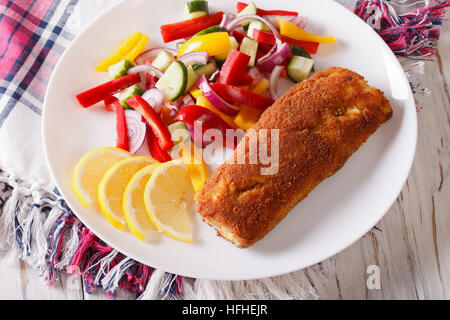 Fritti di filetto di pesce fresco con insalata di verdure sulla piastra closeup. orizzontale Foto Stock