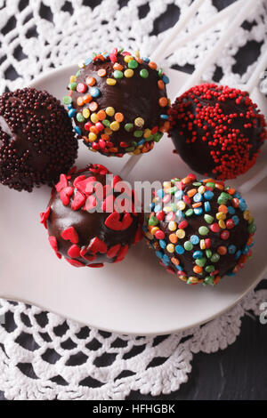 Colorate torte Pop closeup su una piastra bianca sul piano verticale. Foto Stock