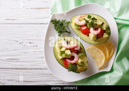 Riempito di avocado con insalata di gamberetti e le verdure su una piastra orizzontale di vista da sopra Foto Stock