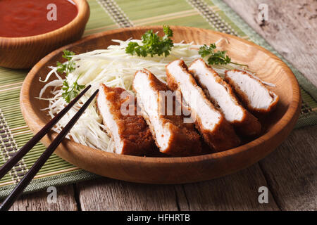 Giapponese profondo panato maiale fritto tonkatsu con cavolo nero e salsa closeup. orizzontale Foto Stock