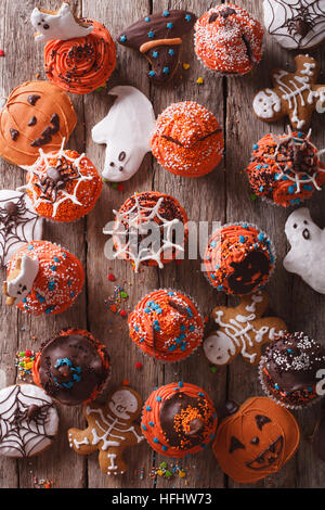 Tortini di Halloween e gingerbread cookies sul tavolo. verticale vista superiore Foto Stock