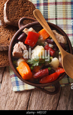 Eintopf con carne, salsicce e verdura vicino sul tavolo. verticale vista superiore Foto Stock