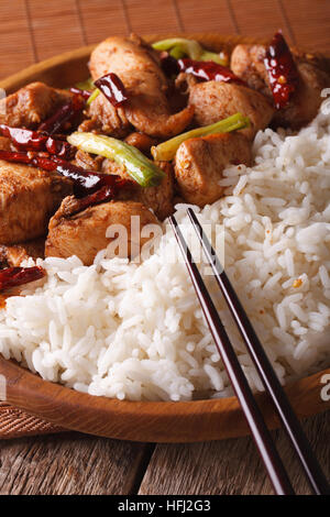Il tradizionale kung pao pollo e riso su una piastra macro. In verticale Foto Stock