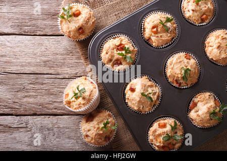 Muffin fatti in casa con prosciutto e formaggio in una teglia. orizzontale vista superiore Foto Stock