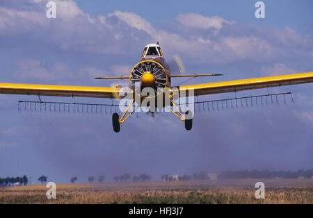 Un giallo raccolto agricolo spolvero aeromobile spruzza un campo di fattoria con pesticidi. Applicazione dell'antenna, o quello che era precedentemente denominato crop spolvero, Foto Stock