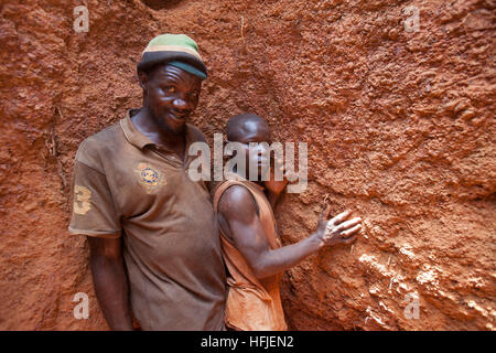 Sanana miniera, Guinea, 2° maggio 2015; Famoroba Camara, nella sua miniera poco profonda a lavorare con il suo amico del figlio, Mamady Conde, 11. Foto Stock