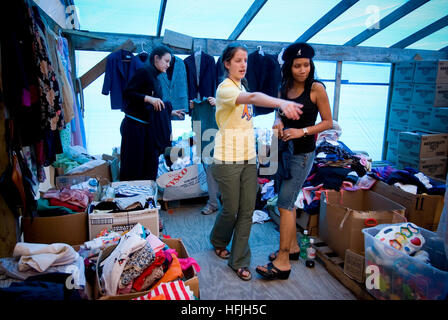 Giovani Vittime dell'Uragano Katrina lavoratori raccogliere cibo abbigliamento e materiali per interessati residenti locali in una chiesa danneggiata. Foto Stock