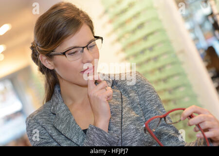 Ritratto di bella donna che indossa gli occhiali in ottico store Foto Stock