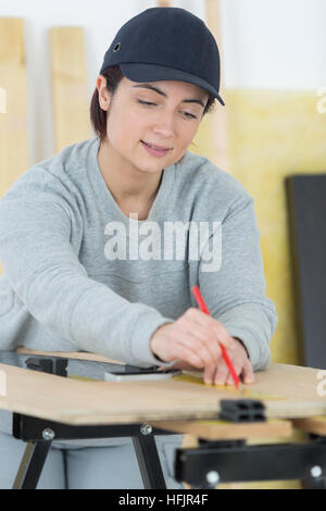 Ritratto di donna felice falegname redazione nuovo progetto in officina Foto Stock