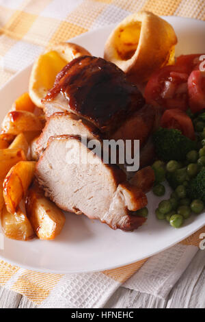 Domenica arrosto di maiale al forno con verdure e Yorkshire pudding. Verticale di close-up Foto Stock