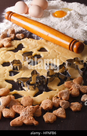 La cottura figured i cookie sul tavolo e gli ingredienti di close-up verticale. Foto Stock
