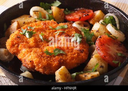 Cotoletta con verdure fritte in padella vicino sul tavolo orizzontale. Foto Stock