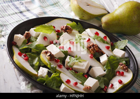 Insalata di pere con melograno, formaggio e rucola vicino sul tavolo orizzontale. Foto Stock