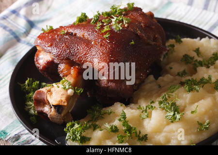 Gambo cotto al forno e purè di patate su una piastra closeup sul tavolo orizzontale. Foto Stock