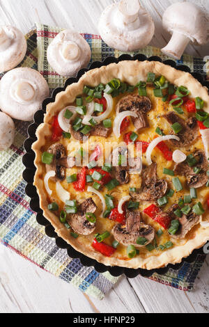 Il francese quiche con funghi vicino sul tavolo. verticale vista superiore Foto Stock