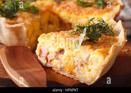 Un pezzo di Francese Quiche Lorraine sul tagliere macro. orizzontale Foto Stock