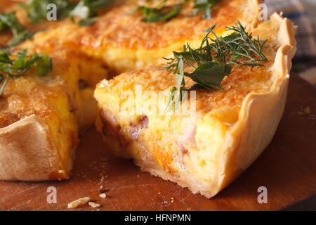 Un pezzo di Quiche Lorraine macro sul tavolo orizzontale. Foto Stock