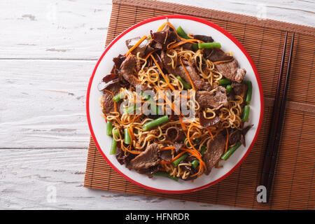 Spaghetti Cinesi con carne di manzo, muer e verdure close-up su una piastra orizzontale di vista da sopra Foto Stock