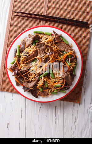 Spaghetti Cinesi con carne di manzo, muer e verdure close-up su una piastra verticale vista superiore Foto Stock