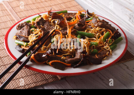 Il cinese lo mein con carne di manzo, muer e verdure close-up su una piastra. Posizione orizzontale Foto Stock