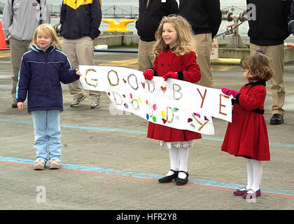 060227-N-8825R-121 Everett, Washington. (Feb. 27, 2006) - La famiglia e gli amici di marinai di stanza a bordo della Nimitz-class portaerei USS Abraham Lincoln (CVN 72) Wave addio dal molo come la nave prende il via dalla stazione navale Everett. Lincoln e Carrier aria Wing due (CVW-2) sono la distribuzione a sostegno della sicurezza marittima operazioni (MSO) e la guerra globale al terrorismo. Stati Uniti Navy foto di PhotographerÕs Mate 3° di classe Aramis Ramirez (rilasciato) Navy US 060227-N-8825R-121 familiari a carico di un marinaio di stanza a bordo del missile destroyer USS Shoup (DDG 86) tenere un segno per il loro padre o Foto Stock