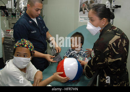 060611-N-3153C-030 Tawi Tawi, Filippine (11 giugno 2006) - Navy Hospital Corpsman 3rd Class Lawrence Santos dell'impianto di trattamento medico a bordo della U.S. Sealift militari di comando (MSC) Nave ospedale USNS misericordia (T-AH 19), controlla la frequenza cardiaca di un bambino locale durante il shipÕs primo giorno in Tawi Tawi. La misericordia è la fornitura di aiuti umanitari al popolo qui sulla sua quarta fermata nelle Filippine durante un periodo di cinque mesi per la distribuzione delle isole del Pacifico e del Sud e del sud-est asiatico. La misericordia è unicamente in grado di supporto di assistenza medica e umanitaria ha bisogno ed è configurato con speciale med Foto Stock