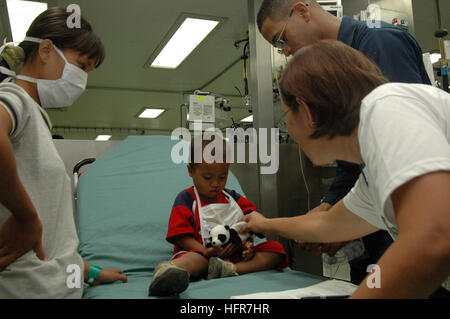 060611-N-3153C-042 Tawi-Tawi -, Filippine (11 giugno 2006) - Ospedale Corpsman Vincente Mendes, da Brooklyn, N.Y., e un impianto di trattamento medico gli stati a bordo della U.S. Sealift militari di comando (MSC) Nave ospedale USNS misericordia (T-AH 19), controlla i segni vitali su un bambino locale durante la nave della prima giornata in Tawi-Tawi -. La misericordia è la fornitura di aiuti umanitari al popolo qui sulla sua quarta fermata nelle Filippine durante un periodo di cinque mesi per la distribuzione delle isole del Pacifico e del Sud e del sud-est asiatico. La misericordia è il personale medico fornirà una moltitudine di personale medico, dentistico e cure veterinarie per animali domestici di PEO Foto Stock