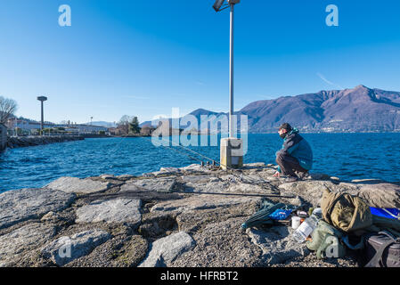 Le avventure di pesca. In inverno la pesca alla carpa in un grande lago Foto Stock